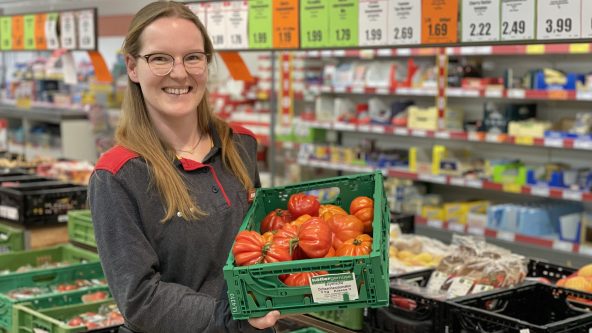 Die duale Studentin in der Norma-Filiale mit einem Korb Obst.