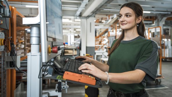 Fachkraft für Lagerlogistik Johanna Meyer bei der Bedienung einer Maschine.